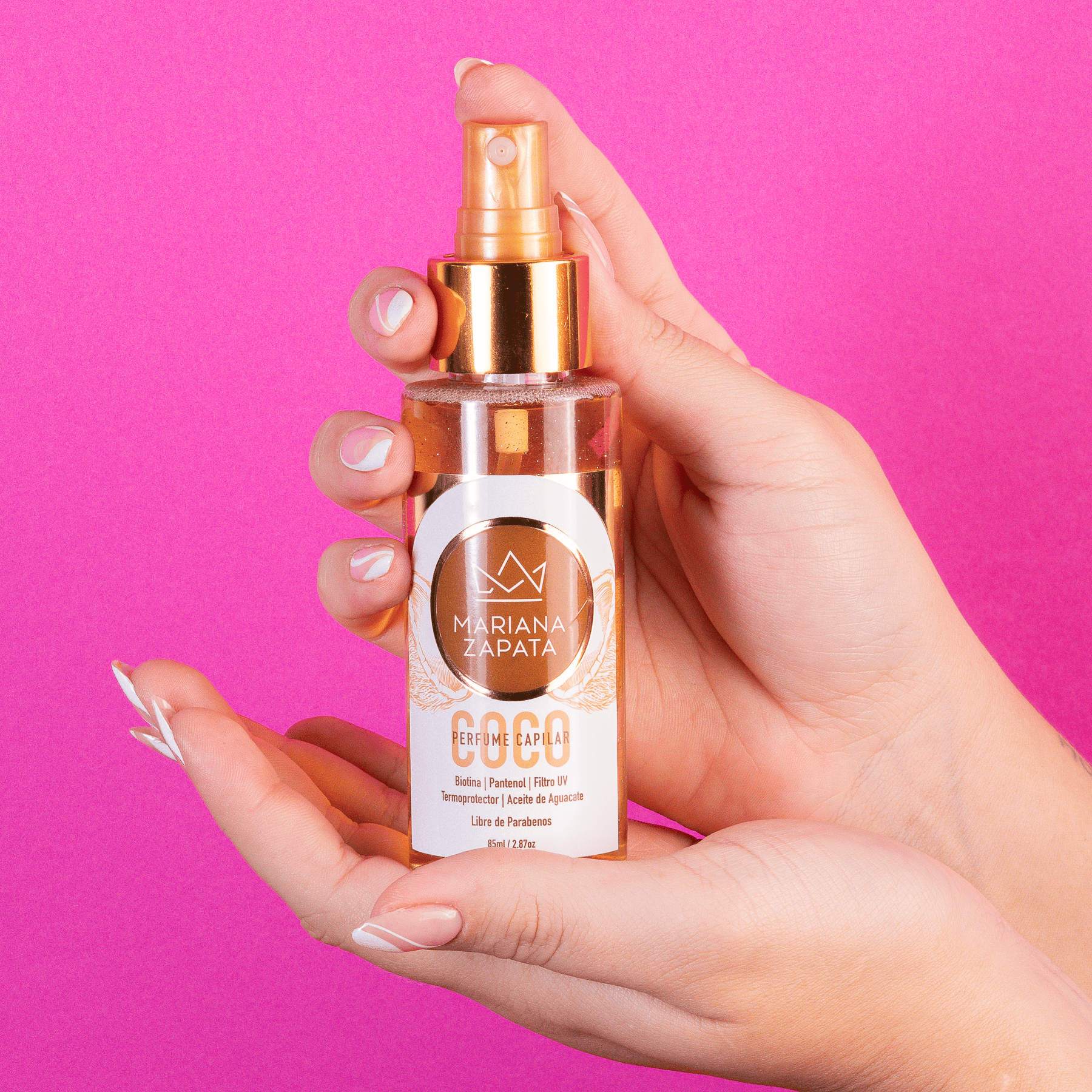 Perfume capilar aroma Coco del Kit Fuerza Capilar en mano, fondo rosa – By Mariana Zapata