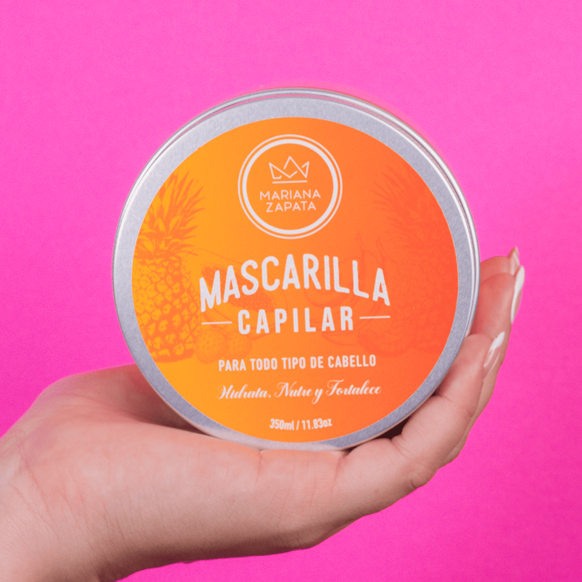 Mascarilla Capilar abierta en mano, fondo rosa – By Mariana Zapata