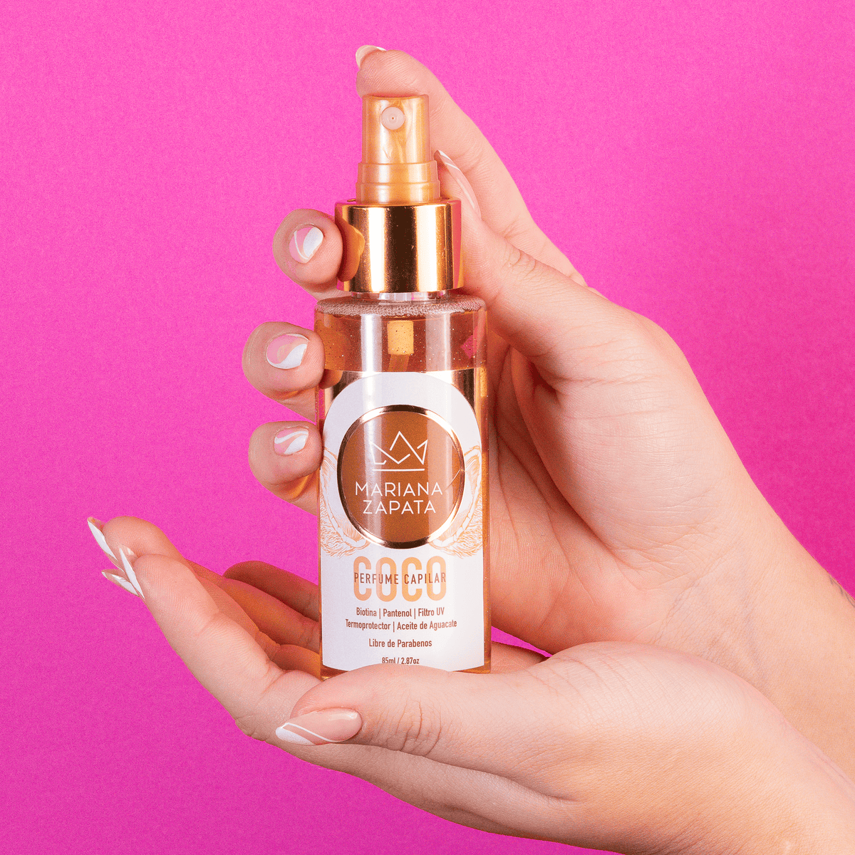 Perfume capilar aroma Coco del Kit Fragancia Total en mano, fondo rosa – By Mariana Zapata