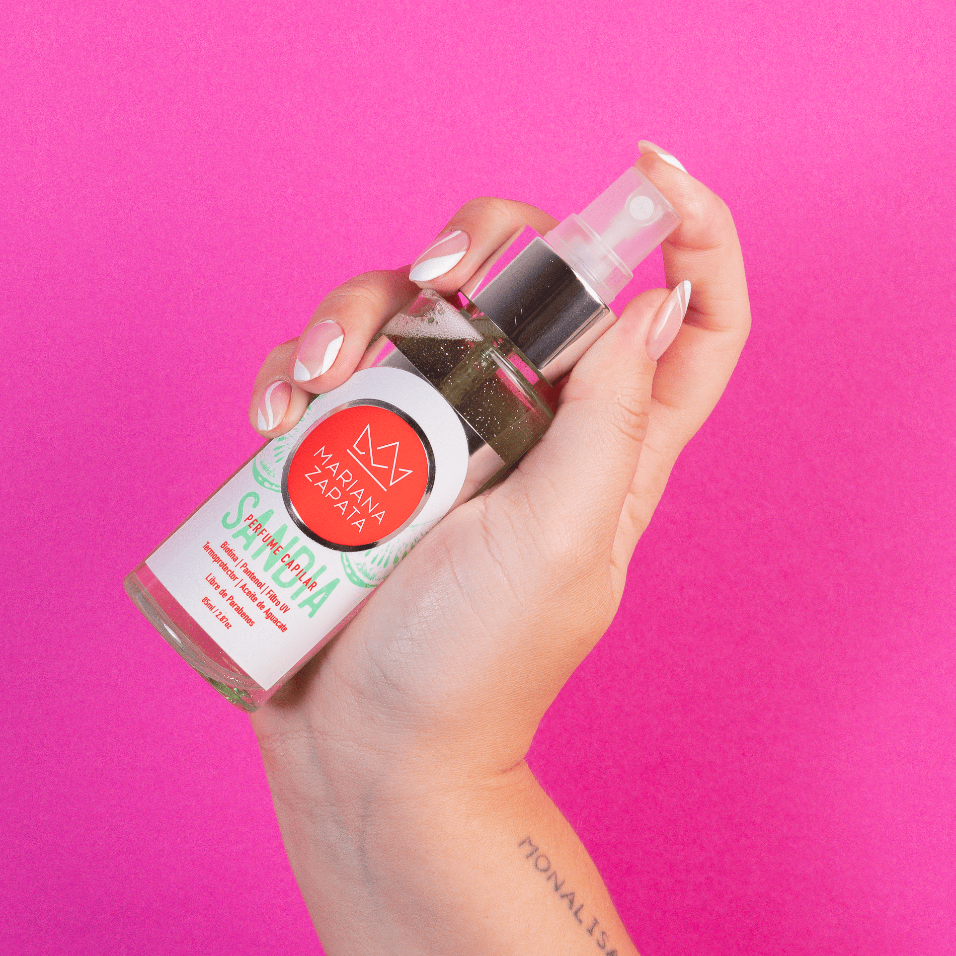 Perfume capilar del Kit Fragancia Total en mano, fondo rosa – By Mariana Zapata