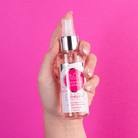 Perfume capilar del Kit Fuerza Capilar en mano, fondo rosa – By Mariana Zapata