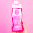 Shampoo del Kit Iconic en mano, fondo rosa – By Mariana Zapata