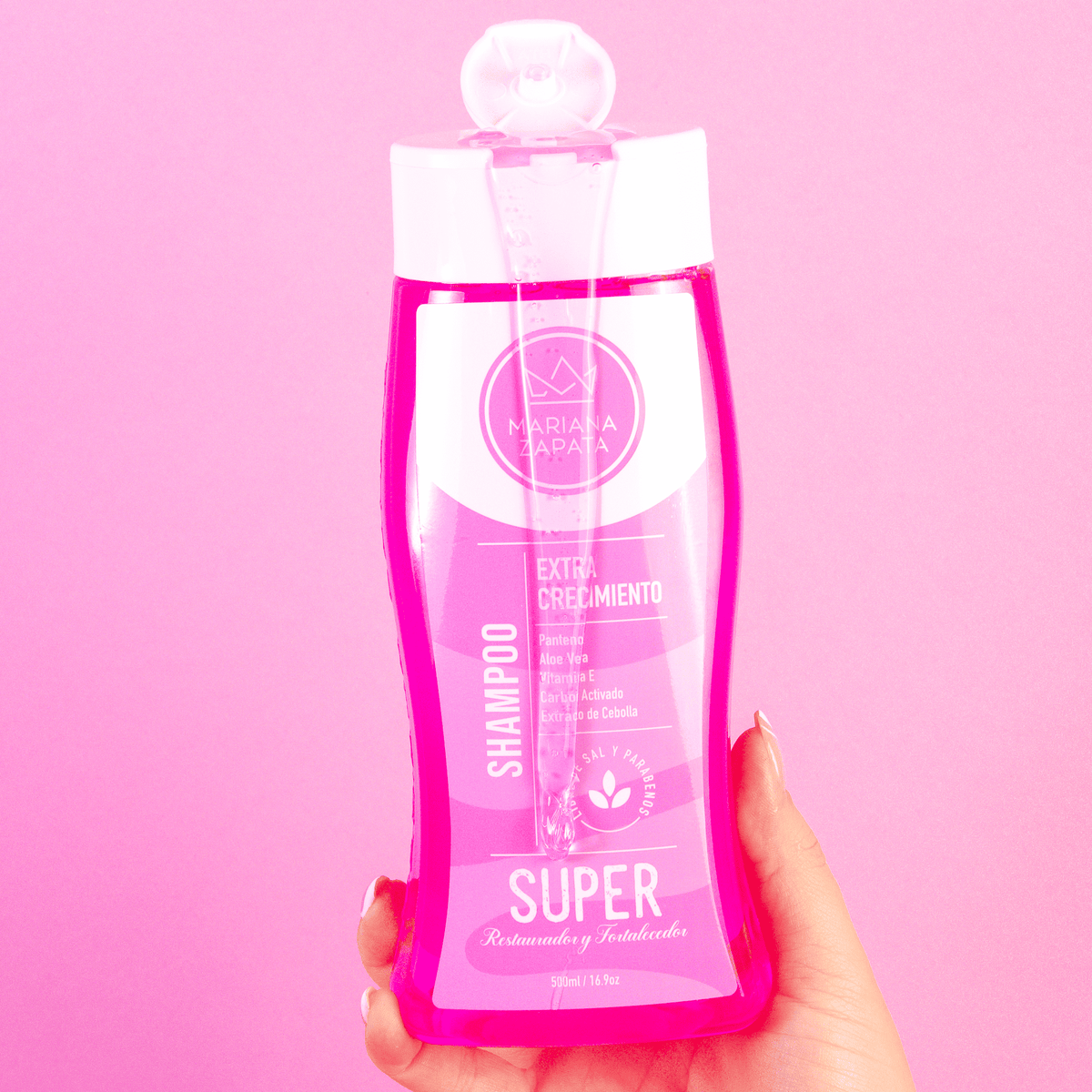 Shampoo del Kit Iconic en mano, fondo rosa – By Mariana Zapata