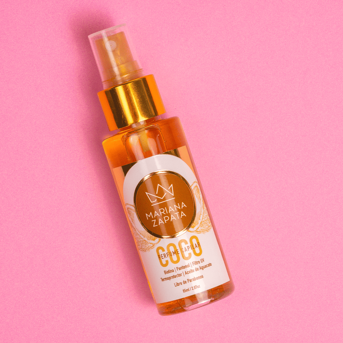 Perfume Capilar de Coco, botella sobre fondo rosa – By Mariana Zapata