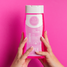 Shampoo Extra Crecimiento, botella de frente sobre fondo rosa – By Mariana Zapata