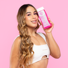 Modelo sosteniendo el Shampoo Extra Crecimiento – By Mariana Zapata